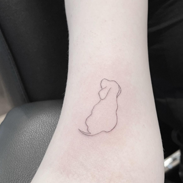 A simple cute fine-line dog tattoo