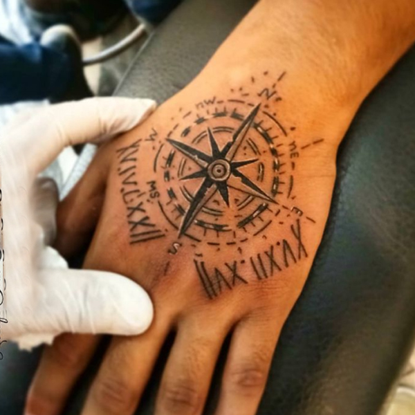 Creative compass and date of birth tattoo on the hand