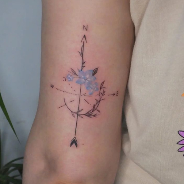 Beautiful compass and flower tattoo on the arm