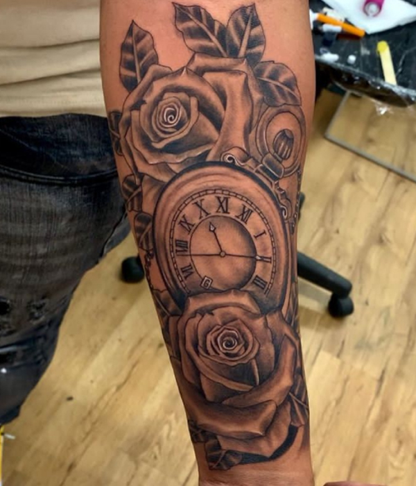 Beautiful clock and rose flower tattoo over the arm