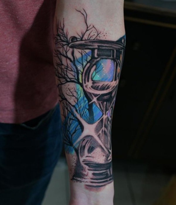 Creative hourglass colorful tattoo over the hand