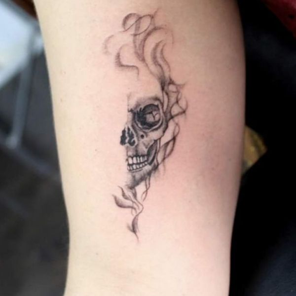 A smokey half-skull small tattoo 